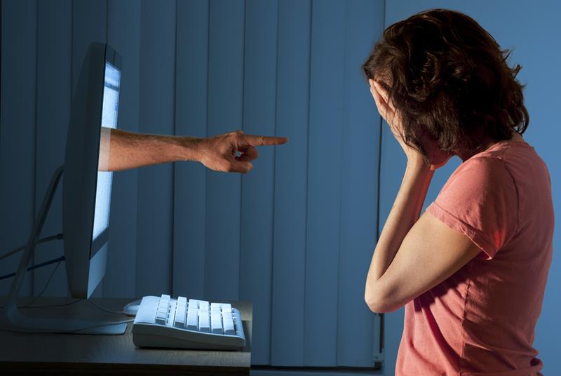 Hand coming out of computer screen pointing at woman scolding her. The internet is a tattoo.